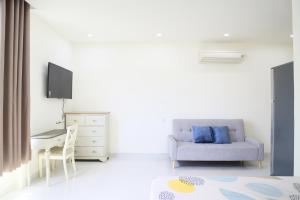 Una sala de estar blanca con un sofá y una mesa. en Victoria Hotel And Apartment, en Ga Tân Thiết