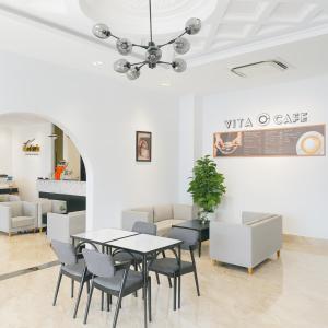 Un comedor con mesa y sillas en Victoria Hotel And Apartment, en Ga Tân Thiết
