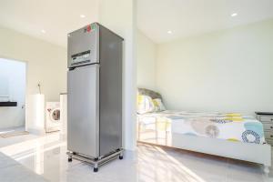 1 dormitorio con nevera junto a la cama en Victoria Hotel And Apartment, en Ga Tân Thiết