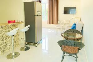 Cette chambre dispose de chaises, d'une table et d'une télévision. dans l'établissement Victoria Hotel And Apartment, à Ga Tân Thiết