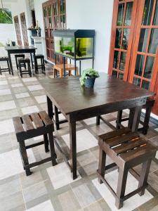 un grande tavolo in legno e panche in una stanza di Seoul Beach Mirissa a Mirissa