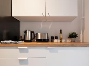 eine Küchentheke mit zwei Kaffeemaschinen und einer Flasche Wein in der Unterkunft BudgetRoom 3 Schlafzimmer Workers Home in Marl