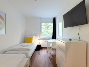 ein Schlafzimmer mit zwei Betten und einem Flachbildfernseher in der Unterkunft BudgetRoom 3 Schlafzimmer Workers Home in Marl
