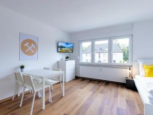 ein weißes Esszimmer mit einem weißen Tisch und Stühlen in der Unterkunft BudgetRoom 3 Schlafzimmer Workers Home in Marl + 6 Fotos