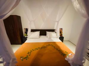 una camera da letto con un letto con una coperta arancione di Seoul Beach Mirissa a Mirissa