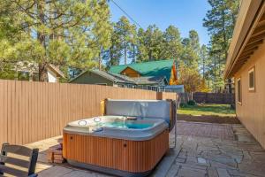 a hot tub sitting on a patio next to a fence at Mountain Cabin with Hot Tub in Flagstaff