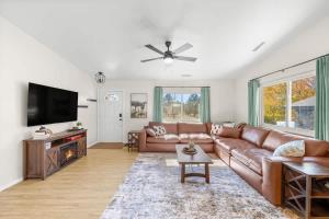 a living room with a couch and a flat screen tv at Mountain Cabin with Hot Tub in Flagstaff +34 photos
