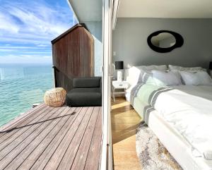 a bedroom with a bed and a balcony with the ocean at Malibu Waterfront Gallery with Private Beach Access in Malibu Beach