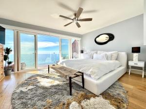 a bedroom with a bed and a large window at Malibu Waterfront Gallery with Private Beach Access in Malibu Beach