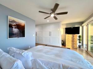 a bedroom with a bed and a ceiling fan at Malibu Waterfront Gallery with Private Beach Access in Malibu Beach