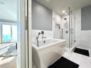 a white bathroom with a tub and a shower at Malibu Waterfront Gallery with Private Beach Access in Malibu Beach +29 photos