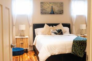 a bedroom with a bed with two night stands and two windows at 2Level Duplex with Jaccuzi-Gem in Chicago 4BD&3BA in Chicago