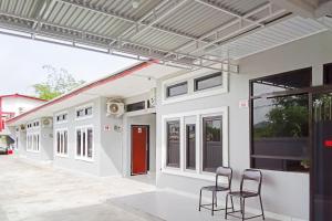 un edificio con dos sillas delante en RedDoorz near Bandara Depati Amir, 