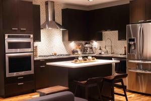 a kitchen with black cabinets and stainless steel appliances at 2Level Duplex with Jaccuzi-Gem in Chicago 4BD&3BA in Chicago