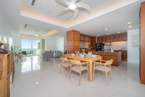 Waterfront 16D seaview 2 BR apartment - 5 min walk to Karon beach في شاطئ كارون: مطبخ وغرفة طعام مع طاولة وكراسي
