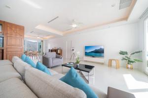 Waterfront 16D seaview 2 BR apartment - 5 min walk to Karon beach في شاطئ كارون: غرفة معيشة مع أريكة وطاولة