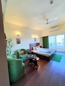 a hotel room with a bed and a couch and chairs at SkyNest in Dehradun