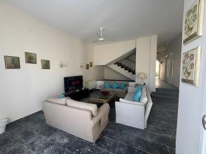 a living room with two couches and a tv at 4 Bedroom Seaside Hurghada Escape in Hurghada