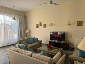 a living room with two couches and a tv at 4 Bedroom Seaside Hurghada Escape in Hurghada +45 photos