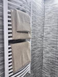 a towel rack with four towels in a bathroom at Saulgrieži 7 in Ventspils