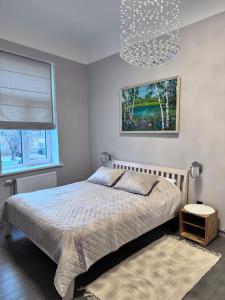 a bedroom with a bed and a chandelier at Saulgrieži 7 in Ventspils