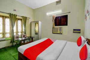 a bedroom with a bed and a table and window at Hotel O A1 Residency in Bhubaneshwar
