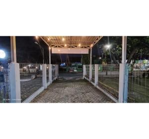 Una cerca blanca con una puerta por la noche en OYO 95042 Jasmine Guest House, en Karangtengah