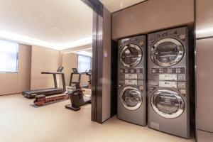 ein Fitnessstudio mit drei Waschmaschinen und Heimtrainern in der Unterkunft JI Hotel Shenzhen Bantian Huawei Base in Shenzhen