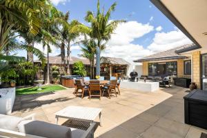 an outdoor patio with a table and chairs at Beach Escape Papamoa in Papamoa