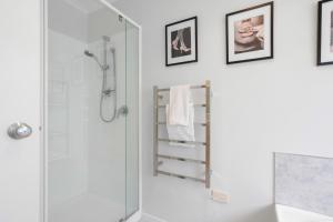 a bathroom with a shower and a glass shower stall at Beach Escape Papamoa in Papamoa +27 photos
