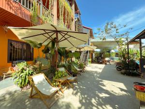 a patio with chairs and an umbrella next to a building at Annamoi Homestay Tam Coc in Ninh Binh
