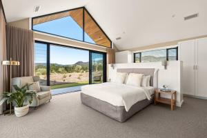 Un dormitorio con una cama y una ventana grande. en Chris' II, Designer Masterpiece in Kangaroo Valley, en Valle Kangaroo 40 fotos más