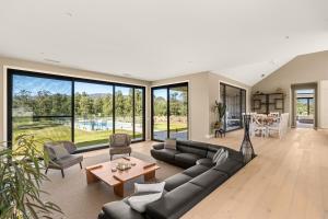 una sala de estar con un sofá y una mesa en Chris' II, Designer Masterpiece in Kangaroo Valley, en Valle Kangaroo