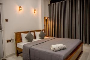 a bedroom with a bed with two towels on it at Shan Resort in Gintota