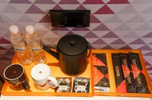 Una bandeja con una cafetera y botellas de agua. en Parkman Hotel Guangzhou Pazhou Convention and Exhibition Center Luntou Branch, en Guangzhou