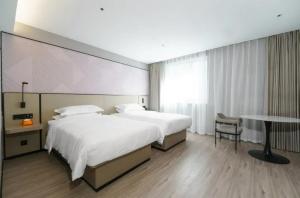 Una habitación de hotel con dos camas y un escritorio. en Parkman Hotel Guangzhou Pazhou Convention and Exhibition Center Luntou Branch, en Guangzhou