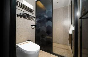 Un baño con inodoro y ducha de cristal. en Parkman Hotel Guangzhou Pazhou Convention and Exhibition Center Luntou Branch, en Guangzhou