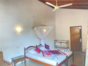 ein Schlafzimmer mit einem Bett und einem Deckenventilator in der Unterkunft Sea Front Hikkaduwa in Hikkaduwa