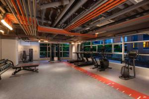 a gym with exercise equipment and a train in the background at East King Business Hotel (West Lake store, Hangzhou) in Hangzhou