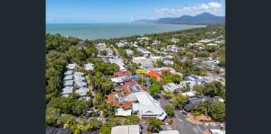 Coconut Palms - In the Heart of Port Douglas & Near the Beach في ميناء دوغلاس: اطلالة جوية على مدينة يوجد بها موقف