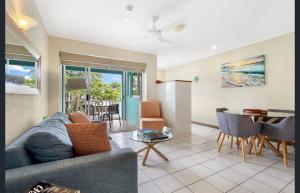 Coconut Palms - In the Heart of Port Douglas & Near the Beach في ميناء دوغلاس: غرفة معيشة بها أريكة وطاولة