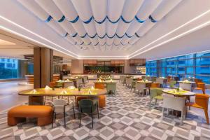 a restaurant with tables and chairs in a cafeteria at East King Business Hotel (West Lake store, Hangzhou) in Hangzhou