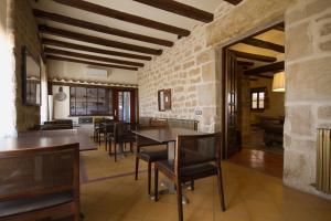 comedor con mesas y sillas y pared de piedra en Hotel Cresol, en Calaceite
