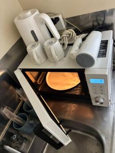 a kitchen counter with a microwave and various appliances at SJins in Tokyo