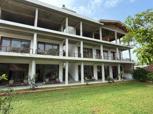 a large building with a lawn in front of it at Lily Mirissa in Mirissa