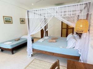 a bedroom with two beds with mosquito nets at Lily Mirissa in Mirissa