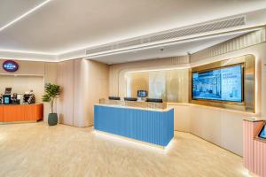 eine Lobby mit einer Rezeption und einem TV in der Unterkunft Hanting Hotel Shanghai Fengxian Situan Baolong Plaza in Fengxian