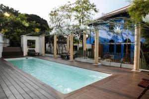 a swimming pool with a wooden deck and a house at Cheong Fatt Tze - The Qing Suites in George Town