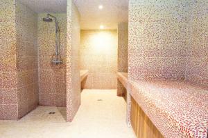 a tiled bathroom with a shower and a tub at EXIGEHOME-Large houseboat with spa near Paris in Saint-Cloud +54 photos
