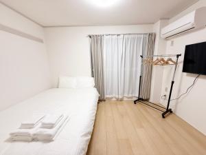 Ένα ή περισσότερα κρεβάτια σε δωμάτιο στο 東三国民泊